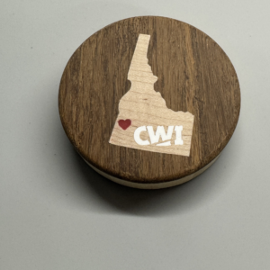 Hockey puck bottle opener with maple Idaho inlay, red epoxy heart over the Treasure Valley, and CWI logo in white epoxy — handmade by Langskegg
