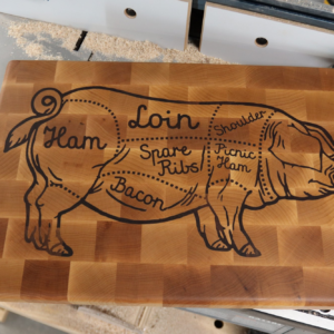End grain maple cutting board with a walnut inlay of a pig butcher chart — Ham, Loin, Shoulder, Spare Ribs, Picnic Ham, Bacon — handmade by Langskegg