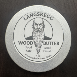 Top view of the Langskegg Wood Butter 4oz tin, food-safe handcrafted wood finish, label showing bearded man logo